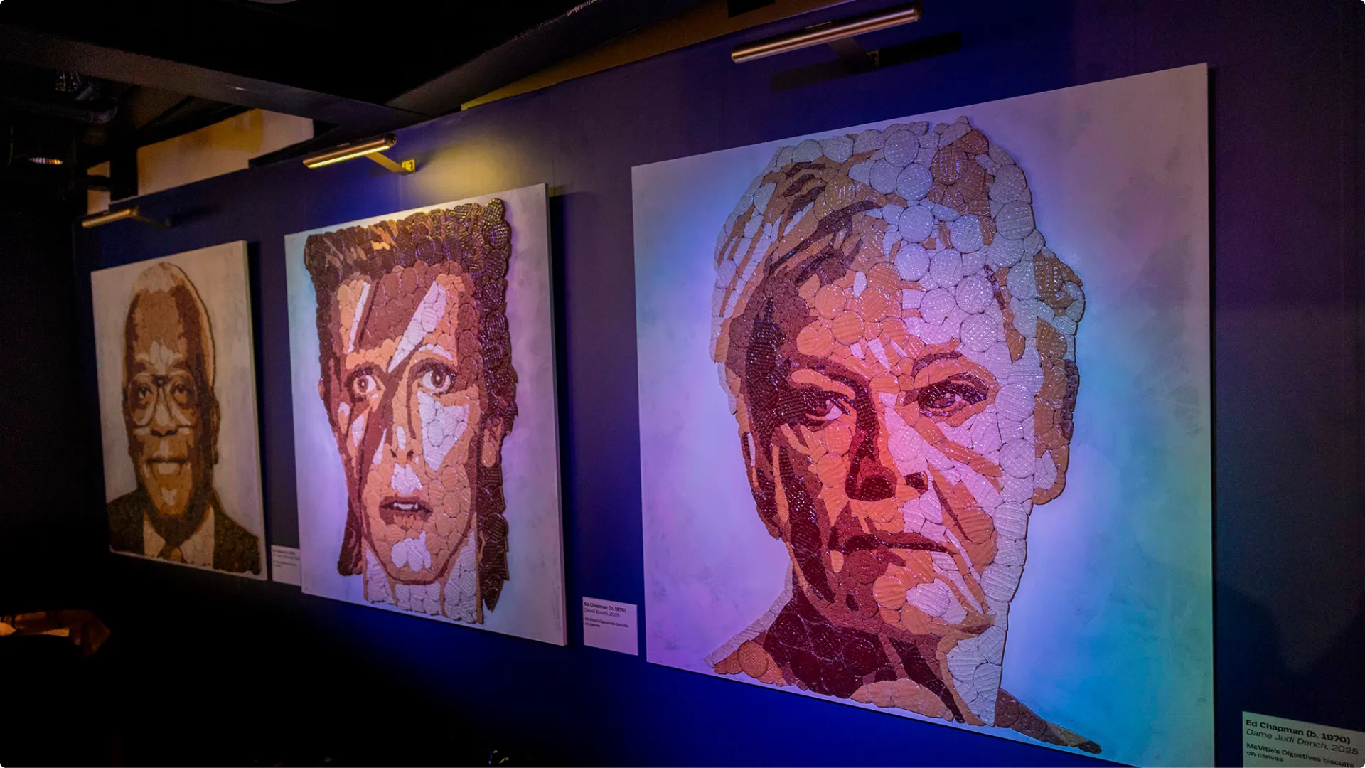 Gallery wall with creative biscuit art portraits of Judi Dench, David Bowie, and Trevor McDonald, made using McVitie’s Chocolate Digestives