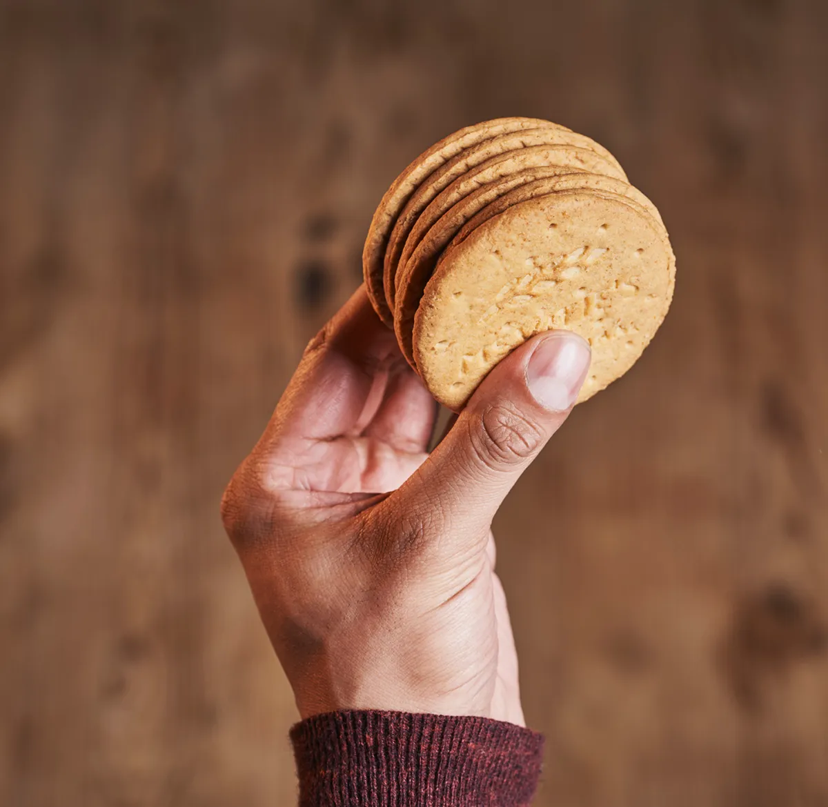 A hand holding a stack of McVite's Digestives